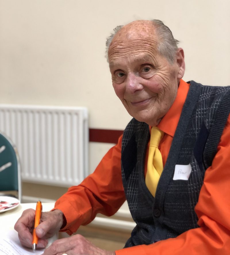 elderly man in orange shirt