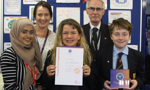 Children and teachers holding award