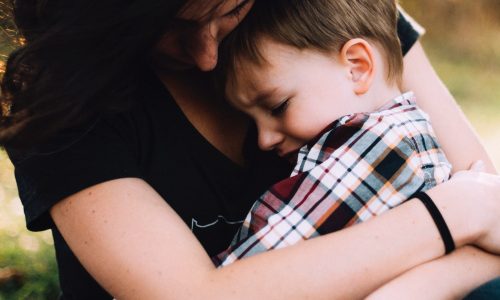 Boy with autism being cuddled by mum
