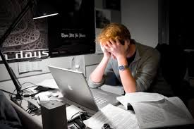 person with head in hands at computer