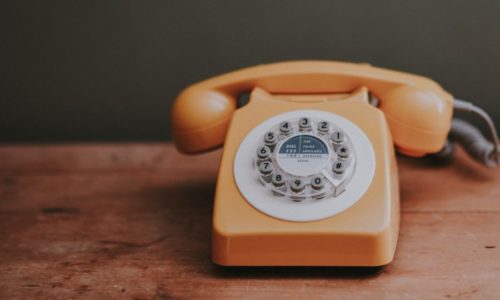 orange telephone on table