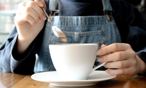 hands stirring cup of coffee