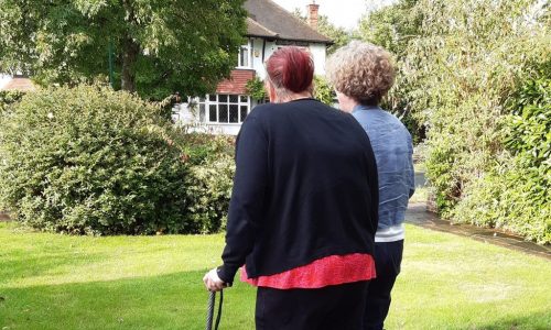 two women walking one with stick
