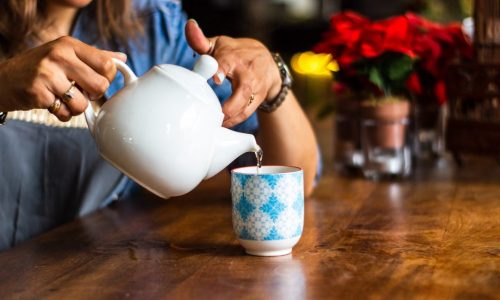 Woman's handspouring cup of tea