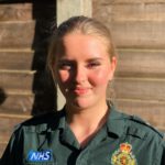 Young woman in ambulance uniform smiling at the camera