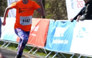 girl running in funrun in orange charity tshirt