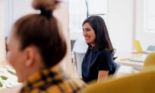 woman smiling with blurred woman