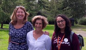 three smiling women in landscape of trees