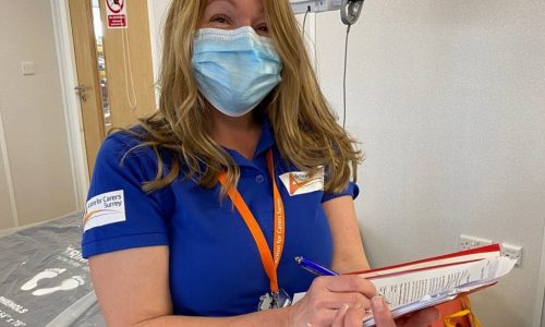 Woman in mask and blue shirt with clipboard