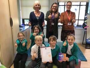 schoolchildren and staff giving thumbs up for an award