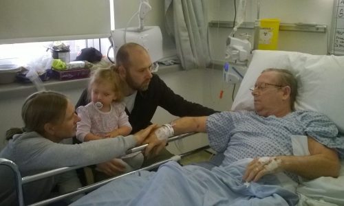 man-hospital-bed-family-visiting