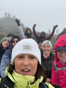 Evelyn Partners Fundraising Team of nine smile as they finish 3 peaks Challenge