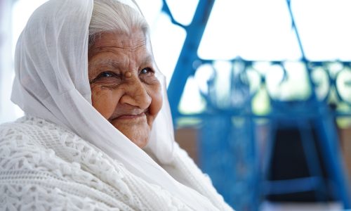Elder Asian lady sat outdoors
