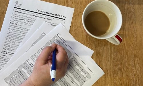 carer filling out carers allowance form