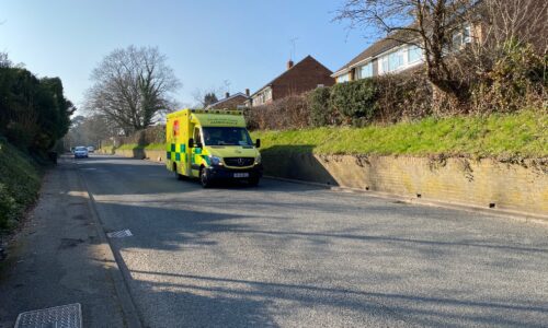 UK-ambulance-driving-down-road-sunny-day
